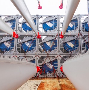 Custom Wind Turbine Component Protective Tarpaulin Covers (Hub & Tower) Blades from wind turbines laid in special fasteners and chained on the deck of the ship for their transportation by sea on a ship.